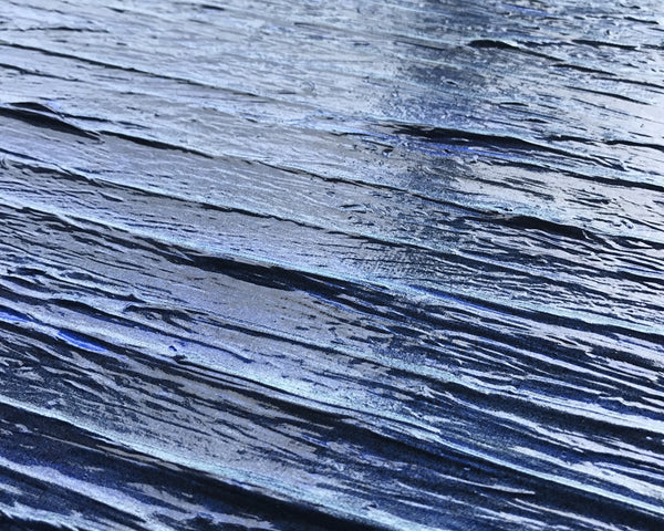 Surface — a high-gloss textured painting of layered blues suggesting the surface of water